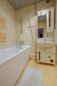 a bathroom with a white tub and a sink at OK! Алексея Беленца 6 in Tomsk