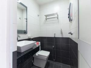 a bathroom with a sink and a toilet and a mirror at Top Garden Hotel in Hutan Melintang