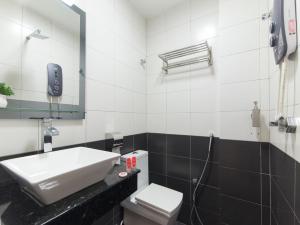 La salle de bains est pourvue d'un lavabo et de toilettes. dans l'établissement Top Garden Hotel, à Hutan Melintang
