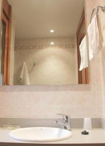 a bathroom with a sink and a mirror at Hostal Cafeteteria Goya in Barbastro