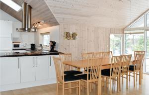 a kitchen and dining room with a wooden table and chairs at Cozy Home In Vggerlse With Wifi in Bøtø By