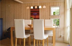 a dining room with a table and white chairs at Holiday Home Bredekjærs-Åsen Græsted V in Udsholt Sand +10 photos