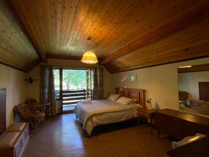 1 dormitorio con cama y techo de madera en Drakensberg Dream, Champagne Valley, en Champagne Valley
