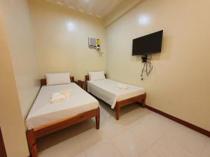 A bed or beds in a room at AMARAV Pension House Nacpan El Nido