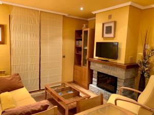 a living room with a fireplace and a tv at El Pino de Cerler in Cerler