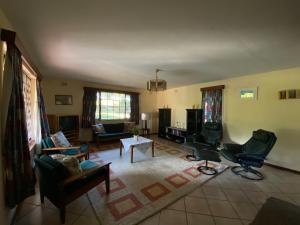sala de estar con sofá, sillas y mesa en Drakensberg Dream, Champagne Valley, en Champagne Valley
