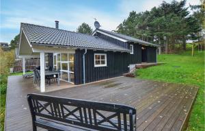ØrbyにあるStunning Home In Knebel With 4 Bedrooms And Saunaの木製デッキ(ベンチ付)のあるブラックハウス