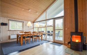 ØrbyにあるStunning Home In Knebel With 4 Bedrooms And Saunaのダイニングルーム(テーブル、暖炉付)