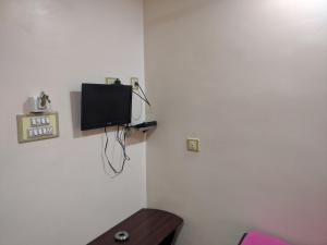 Ecke eines Zimmers mit einem TV an der Wand in der Unterkunft Sakthimurugan residency in Erode