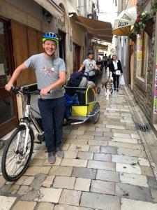 un hombre con una bicicleta y un carro en una calle en Accomodation Gina, en Zadar