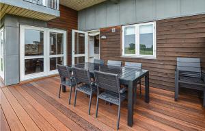 un tavolo nero e sedie su una terrazza in legno di Pet Friendly Home In Faaborg With Kitchen a Faaborg