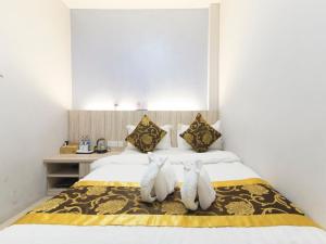 deux animaux farcis assis sur un lit dans une pièce dans l'établissement Top Garden Hotel, à Hutan Melintang