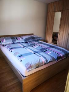 ein Bett in einem Schlafzimmer mit einem Bettrahmen aus Holz in der Unterkunft Petit Paradisli in Täsch