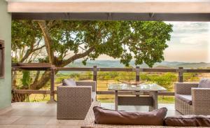 d'une terrasse avec une table et des chaises offrant une vue. dans l'établissement @Nature Luxury Cottages, à Nelspruit