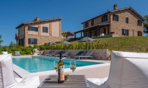 a bottle of wine on a table next to a pool at Borgo Crispiero in Crispiero