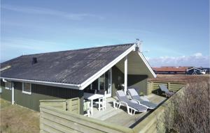 a house with a deck with chairs and a table at Holiday Home Arvidvej I Dnmk in Bjerregård