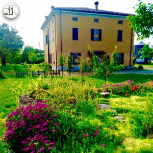a house with a garden with flowers in front of it at CAMINATA 415 in Fiorenzuola dʼArda
