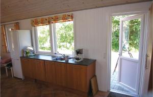 VestervigにあるHoliday Home Vestervig With Sauna 170のカウンター付きのキッチン、窓2つが備わります。 +5枚の写真