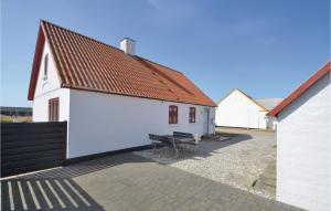 FrøstrupにあるAmazing Home In Frstrup With 4 Bedrooms And Wifiの赤い屋根とベンチのある白い建物