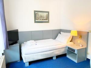Postel nebo postele na pokoji v ubytování Altstadthotel Augsburg
