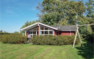 a red house in the middle of a field at Three-Bedroom Holiday Home In Humble in Humble