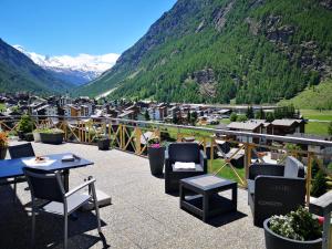 a patio with chairs and tables and a mountain at Petit Paradisli in Täsch