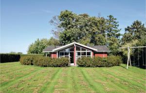 a red house with a field in front of it at Three-Bedroom Holiday Home In Humble in Humble