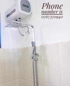 La salle de bains est pourvue d'une douche avec un pommeau de douche. dans l'établissement Hotel First Kingdom - Anuradhapura, à Anurâdhapura