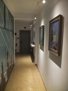 a hallway with paintings on the walls of a building at #iRicci3stanze in Monfalcone