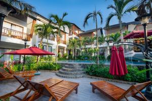 a resort with a pool and benches and palm trees at Melica Resort Phu Quoc in Phu Quoc