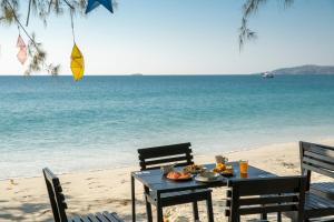 a table with food sitting on the beach at Avatara Resort in Ko Samed