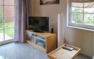 a living room with a flat screen tv on a wooden entertainment center at 2 Bedroom Gorgeous Home In Hohenkirchen in Hohenkirchen