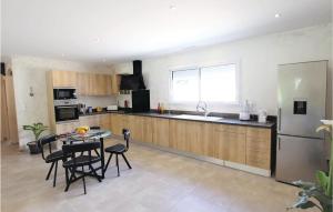a kitchen with a table and chairs and a refrigerator at Stunning Home In Monteux in Monteux