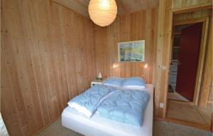 トランにあるNice Home In Lgstr With 3 Bedrooms, Sauna And Wifiの木製の壁のベッドルーム1室