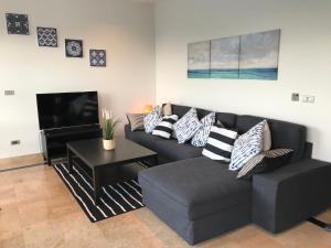 Una sala de estar con un sofá y un televisor. en 3BR Beautiful New Villa Mikia SDV007 with amazing Sea and Mountain Views-By Samui Dream Villas, en Mae Nam