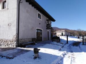 a building with a fire hydrant in the snow at Locanda Mulino del Barone by VM in Opi