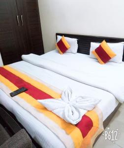 a bedroom with two beds with a colorful blanket at Kundan Plaza Jasola in New Delhi