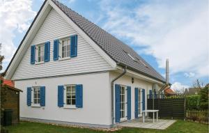 a white and blue house with blue shutters at 2 Bedroom Gorgeous Home In Hohenkirchen in Hohenkirchen