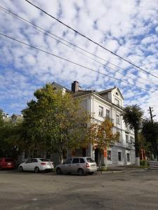 two cars parked in front of a white building at Kremlyovskaya Apartament in Vladimir