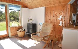 a living room with a rocking chair and a stove at Holiday Home Vestermarken Blåvand Iv in Blåvand