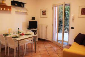 een woonkamer met een tafel en stoelen en een televisie bij Ca' Eli 2 in Oliveto Lario