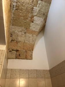 ナルドにあるCorte La Rosaの石壁とタイルフロアのバスルーム