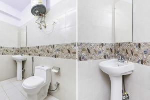 a white bathroom with a toilet and a sink at Kundan Plaza Jasola in New Delhi
