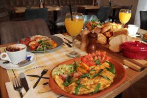 una mesa de madera con un plato de comida y bebida en Urban Lodge Belgrade en Belgrado