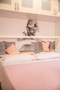 Ce lit se trouve dans un dortoir doté d'un dessin mural. dans l'établissement La Zattera Camere, à San Vincenzo