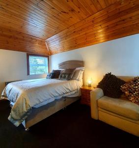 a bedroom with a bed and a couch in a room at Groom's Cottage in Moffat