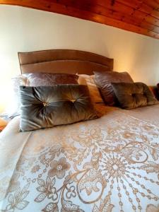 een bed met kussens in een slaapkamer bij Groom's Cottage in Moffat