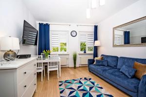 ein Wohnzimmer mit einem blauen Sofa und einem Tisch in der Unterkunft Central Apartments Ogarna in Danzig