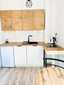 Apartament Salton في بوخنية: مطبخ مع دواليب بيضاء ومغسلة