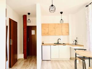 a kitchen with white cabinets and a table at Apartament Salton in Bochnia